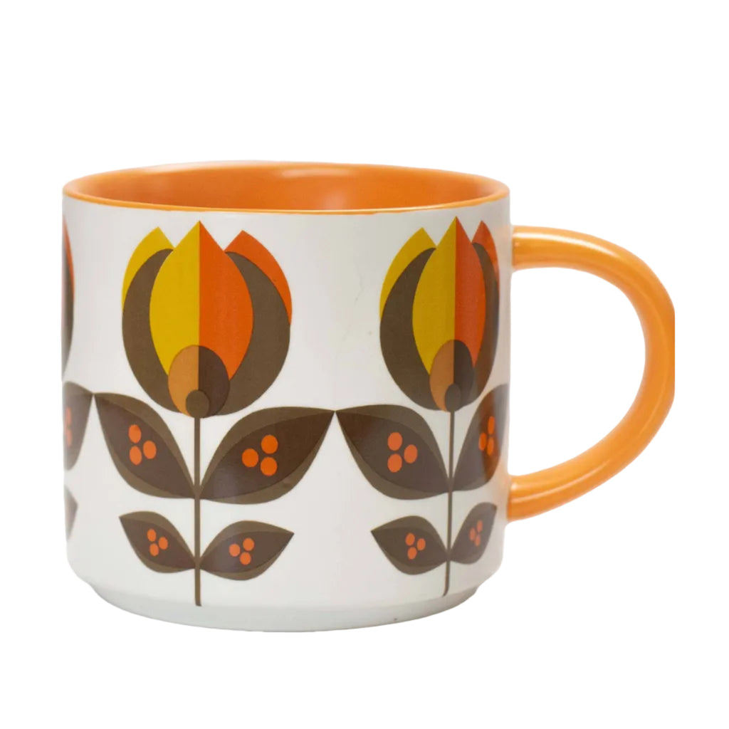 A white ceramic mug with a retro mid-century modern floral pattern in orange, yellow, and brown, featuring a solid orange handle and interior.