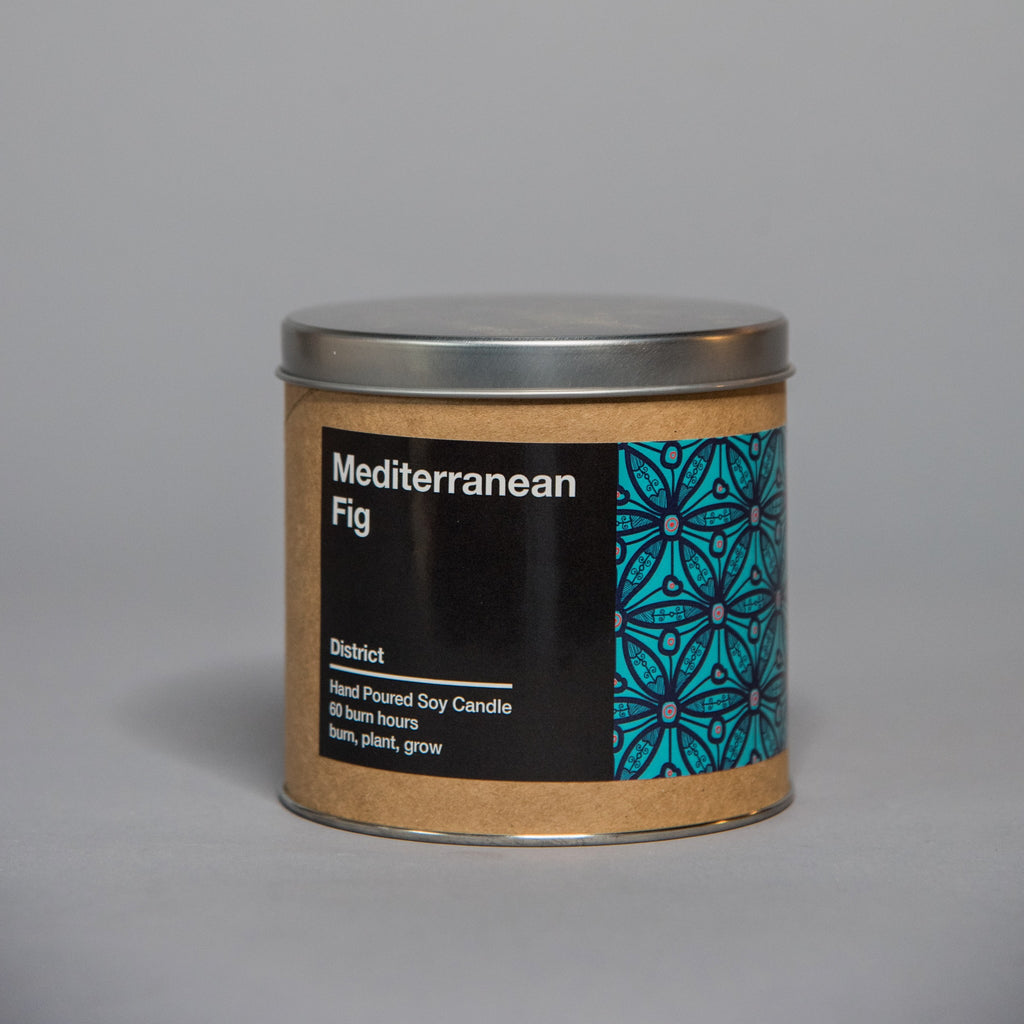 Small tin container candle with Mediterranean fig scent and decorative blue geometric pattern on label