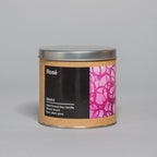 Small hand-poured soy candle in a metal tin with a brown label featuring pink abstract artwork and black text
