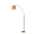 Modern arc floor lamp with a brass finish and a round beige fabric drum shade for home decor lighting.