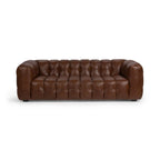 Brown tufted leather sofa with deep cushioning and rounded armrests in a modern design.