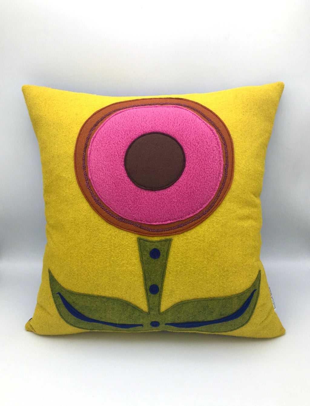 Yellow wool felt pillow with a simple pink and brown flower design and green leaves and stem decor.