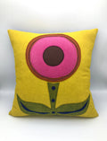 Yellow wool felt pillow with a simple pink and brown flower design and green leaves and stem decor.