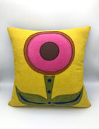 Yellow wool felt pillow with a simple pink and brown flower design and green leaves and stem decor.