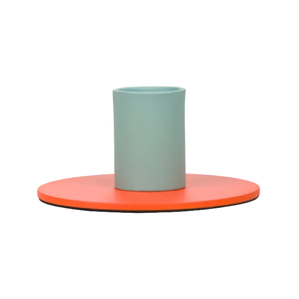 Minimalist two-tone metal candle holder with a muted teal cylindrical base and bright orange flat circular plate