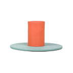 Minimalist two-tone metal candle holder with orange cylindrical holder and flat pale green base for home decor.