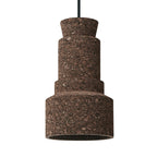 Small pendant light with textured cork material and modern geometric shape hanging from a cord