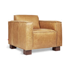 Modern tan leather armchair with boxy shape and wooden block legs, suitable for stylish home decor.