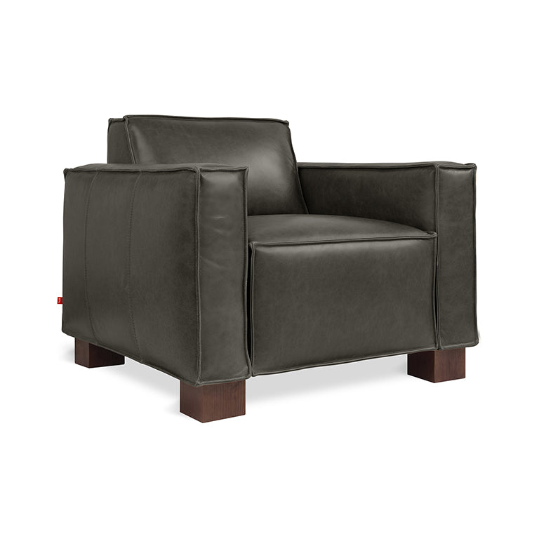 Dark brown leather armchair with wide arms and wooden block legs, showcasing modern and comfortable design.
