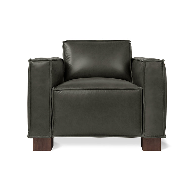 Contemporary black leather armchair with wide armrests and wooden block legs in a modern design