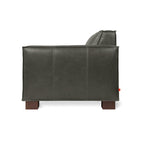 Side view of a dark gray leather chair with wooden block legs and clean, modern design