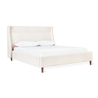 Cream upholstered bed with a tall padded headboard and wooden legs, styled with two white pillows and mattress