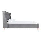 Side view of a contemporary gray upholstered bed frame with tall padded headboard and wooden legs