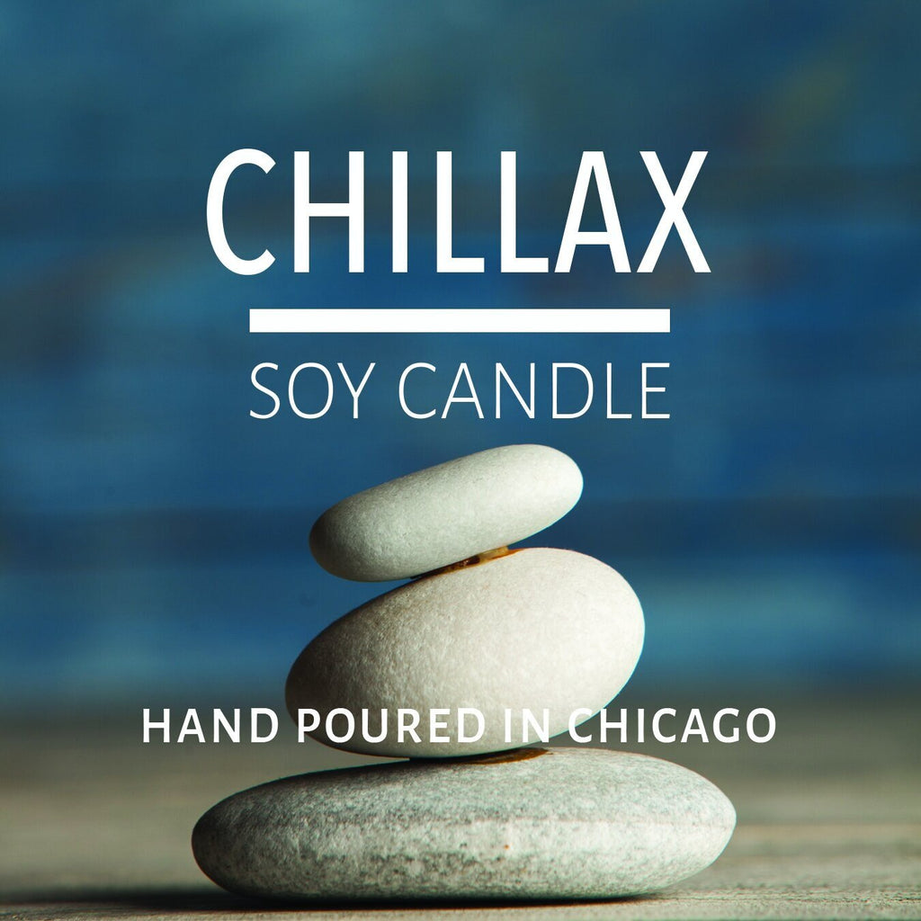 Stacked smooth stones with blurred blue background promoting a hand-poured soy candle from Chicago