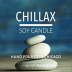 Stacked smooth stones with blurred blue background promoting a hand-poured soy candle from Chicago