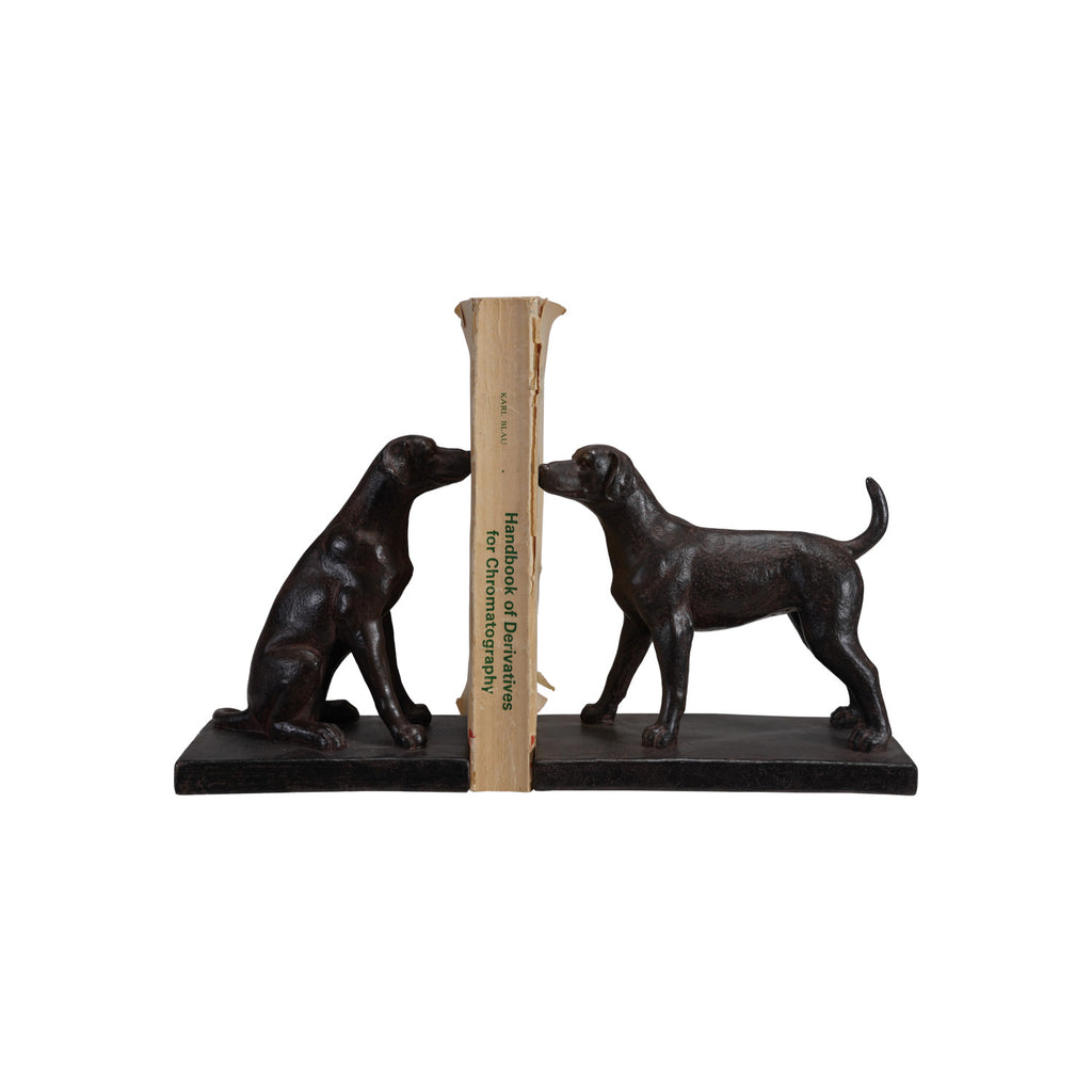 Black bookends shaped like dogs holding book on a white background