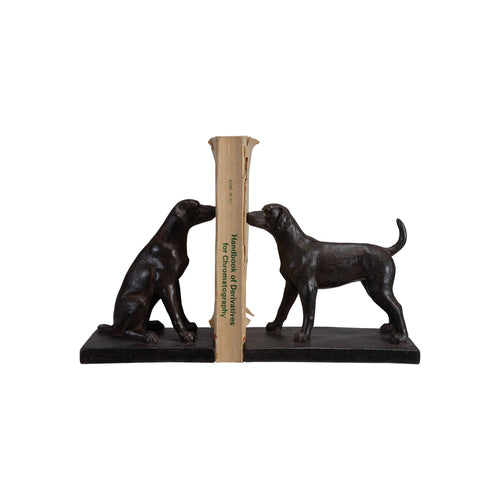 Black bookends shaped like dogs holding book on a white background
