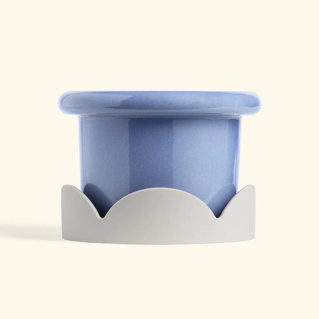 Blue ceramic drip tray with beige petal-shaped base designed for home decor or planter protection