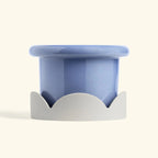 Blue ceramic drip tray with beige petal-shaped base designed for home decor or planter protection