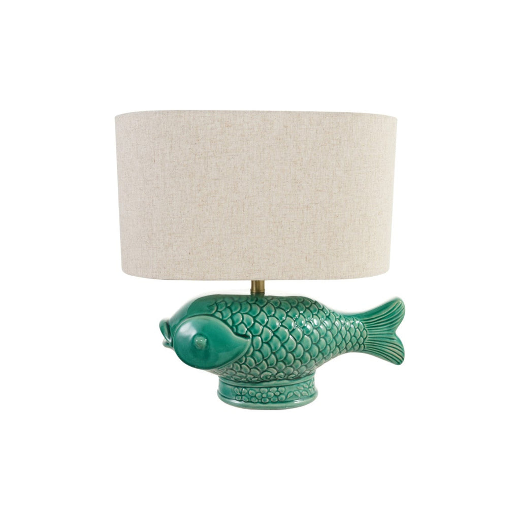 A table lamp featuring a glossy green fish-shaped ceramic base and a cylindrical beige fabric drum shade, shown against a plain white background.