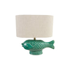 A table lamp featuring a glossy green fish-shaped ceramic base and a cylindrical beige fabric drum shade, shown against a plain white background.