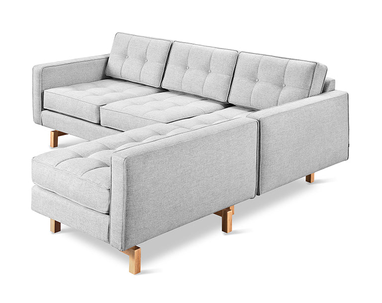 Light gray fabric bi-sectional sofa with tufted cushions and wooden legs in a modern minimalist style