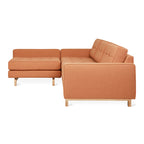 Modern orange fabric sectional sofa with tufted back cushions and wooden legs against white background