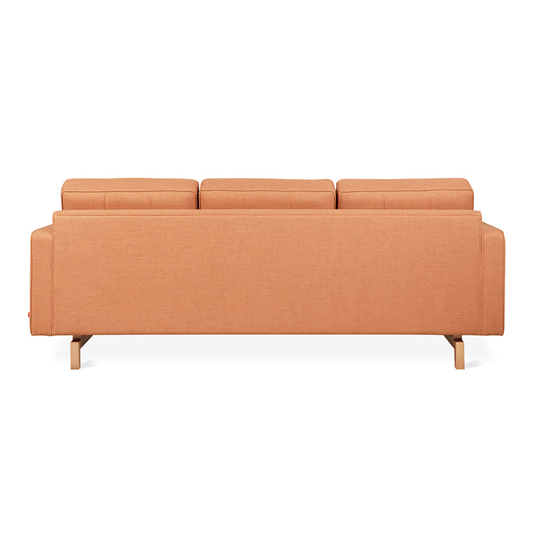 Back view of a modern orange fabric sectional sofa with wooden legs and adjustable headrests