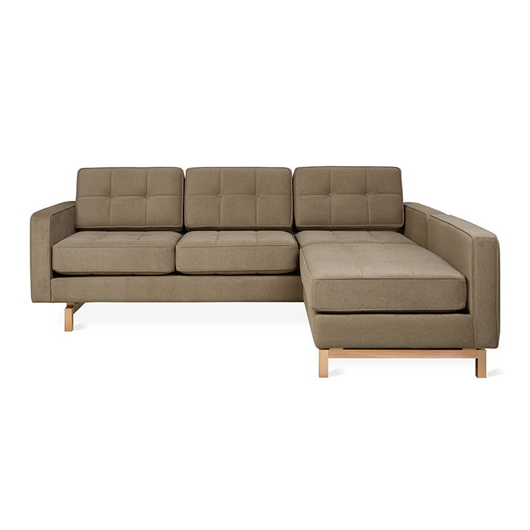 Modern bi-sectional sofa with natural mocha upholstery and wooden legs, featuring tufted cushions and clean lines.