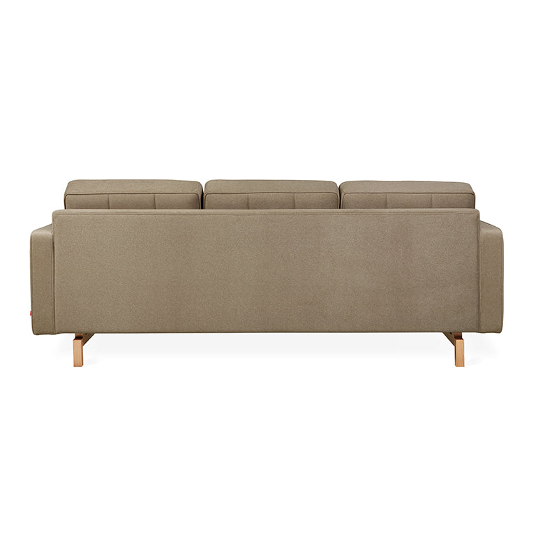 Back view of a modern beige fabric sectional sofa with wooden legs and three cushioned seats