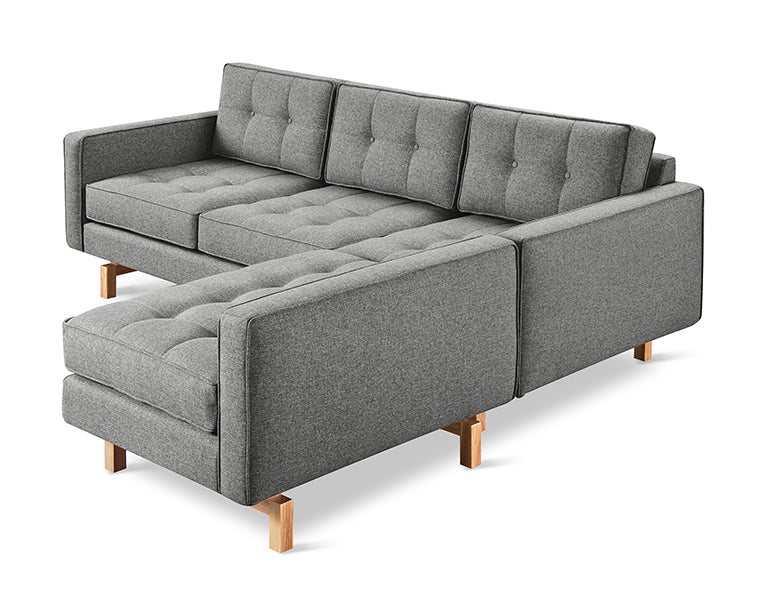 Gray modern bi-sectional sofa with tufted cushions and wooden legs on a white background