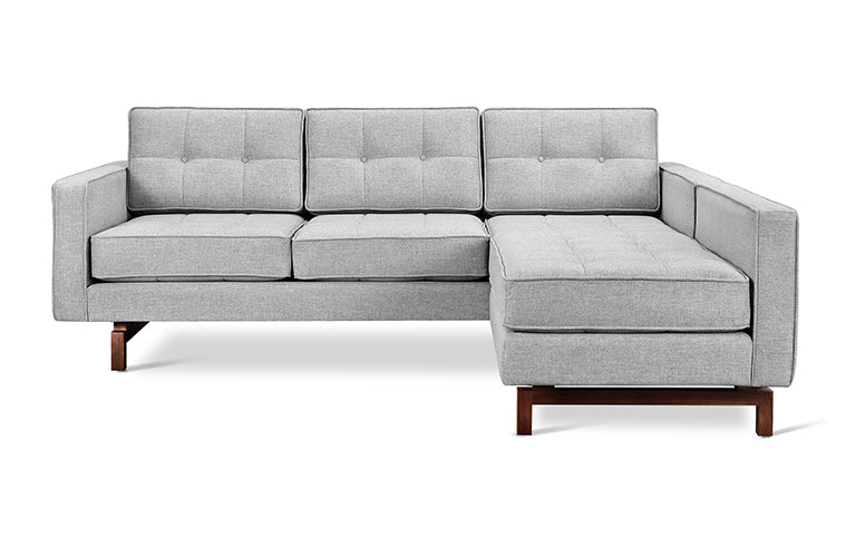 Gray fabric midcentury modern bi-sectional sofa with tufted cushions and walnut-finished wooden legs.