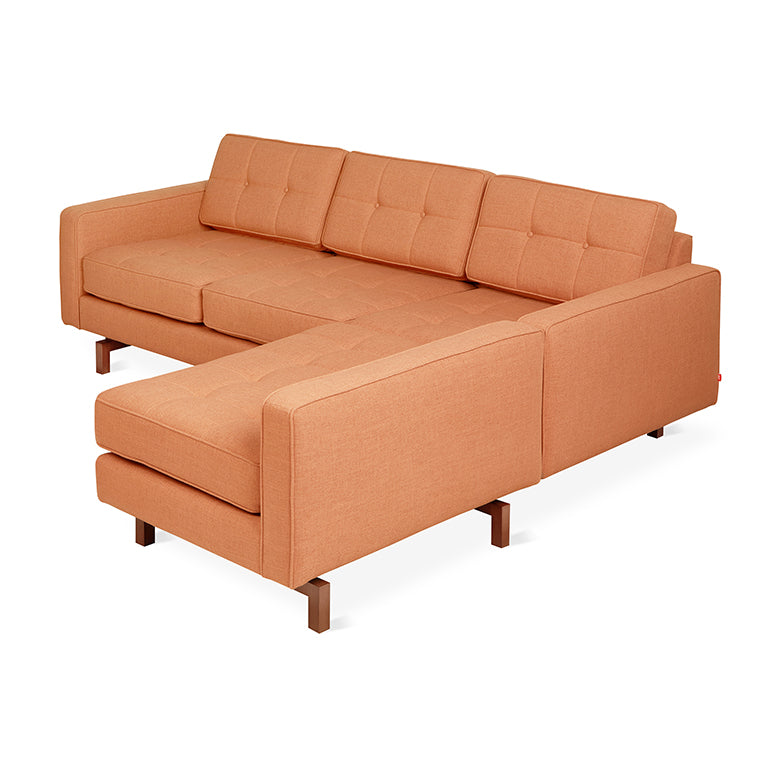 Modern midcentury-inspired orange fabric bi-sectional sofa with tufted cushions and wooden legs.