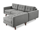 Modern gray fabric bi-sectional sofa with tufted cushions and wooden legs designed for comfortable seating.