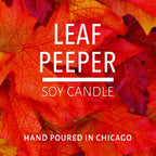 Close-up of vibrant orange and red autumn leaves with text about a soy candle hand poured in Chicago.