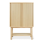 Wooden tall cabinet with vertical slatted doors and open lower shelf in a light oak finish