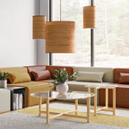 Three large wooden pendant lights hanging above a modern living room with sectional sofa and glass tables