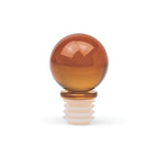 An amber glass bottle stopper with a rounded, polished sphere on a ridged white base, shown on a clean white background.