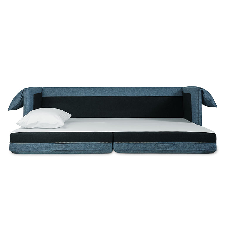 Modern blue fabric sofabed with black cushioned base and white pillow on a minimalist white background