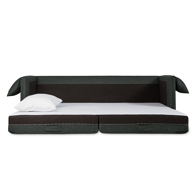 Modern sofa bed in dark fabric fully extended with white pillow on mattress surface