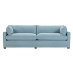 Light blue denim sofa with clean lines, plush cushions, and wooden block legs, ideal for modern living spaces