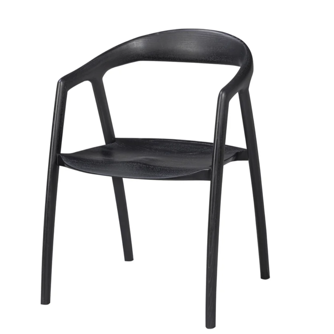 A modern black molded plastic dining chair with a curved backrest and four legs, shown from a three-quarter angle on a plain white background.