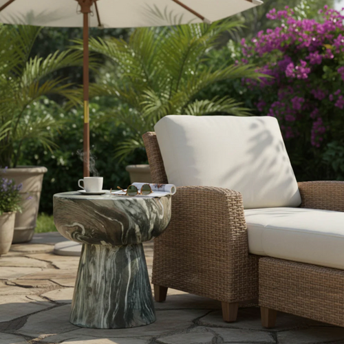 Outdoor patio setup with a marble-patterned side table next to a wicker armchair with white cushions and umbrella shade