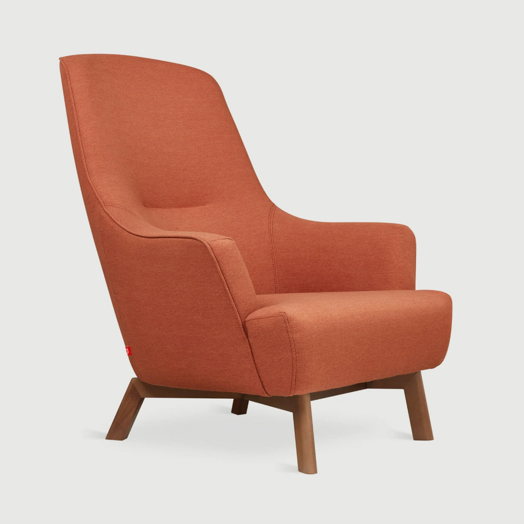 An orange upholstered armchair with a tall curved back and tapered wooden legs, shown against a light gray background.
