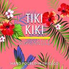 Tropical floral artwork with green leaves, red hibiscus flowers, and a blue hummingbird on a pink background.