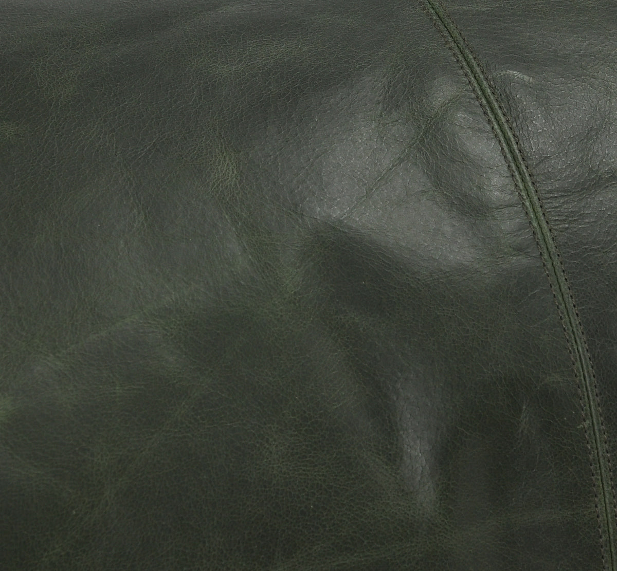 Close-up of dark green leather texture with visible stitching detail on a lumbar pillow surface.