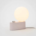 Minimalist modern lamp with a glowing round LED bulb and a dimmable control on a rectangular base