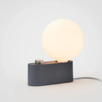 Modern dimmable lamp with a round glowing LED bulb and matte charcoal base for ambient lighting
