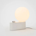 Minimalist white LED lamp with a round glowing dimmable light and rectangular base for modern home decor