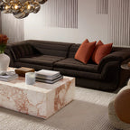 Modern living room with a brown sectional sofa, marble coffee table, and decorative items.